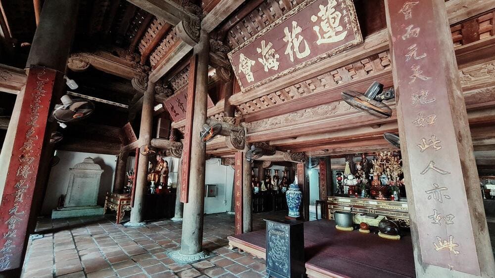 Gian điện thờ b&ecirc;n trong ch&ugrave;a vẫn giữ được n&eacute;t xưa cổ với nền l&aacute;t gạch, c&aacute;c cột gỗ rường ch&egrave;o, c&acirc;u đối đỏ v&agrave; ho&agrave;nh phi trang tr&iacute; (Nguồn: B&aacute;o D&acirc;n Việt)